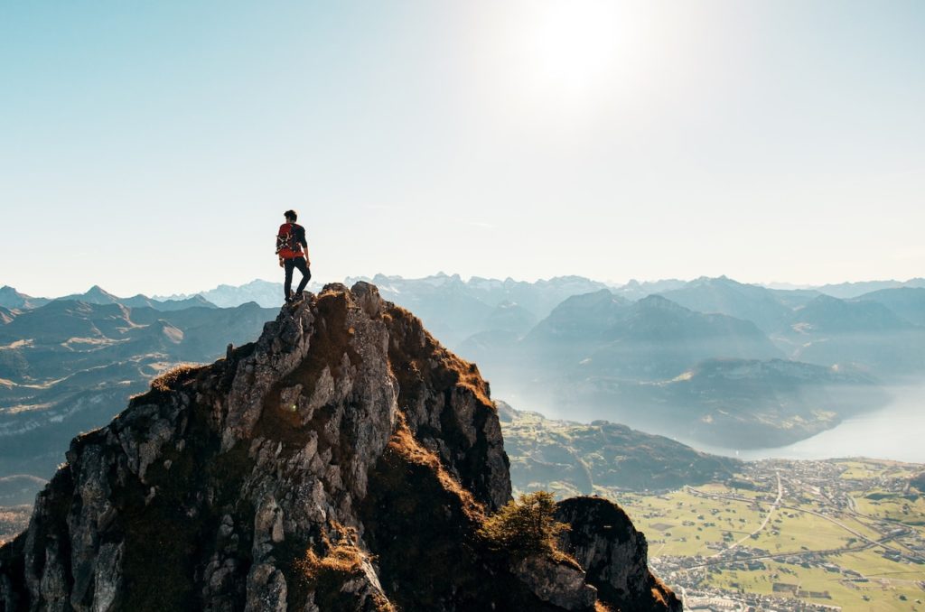 A man standing on a peak of a mountain.