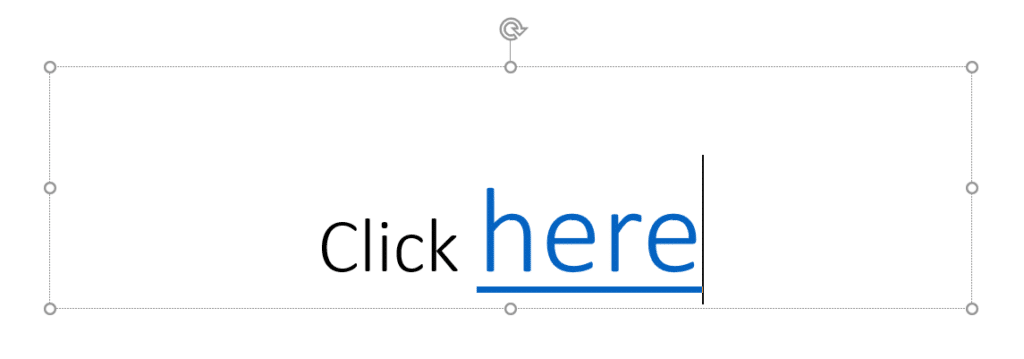 The text "Click here" in PowerPoint, with hyperlink on the word 'here'